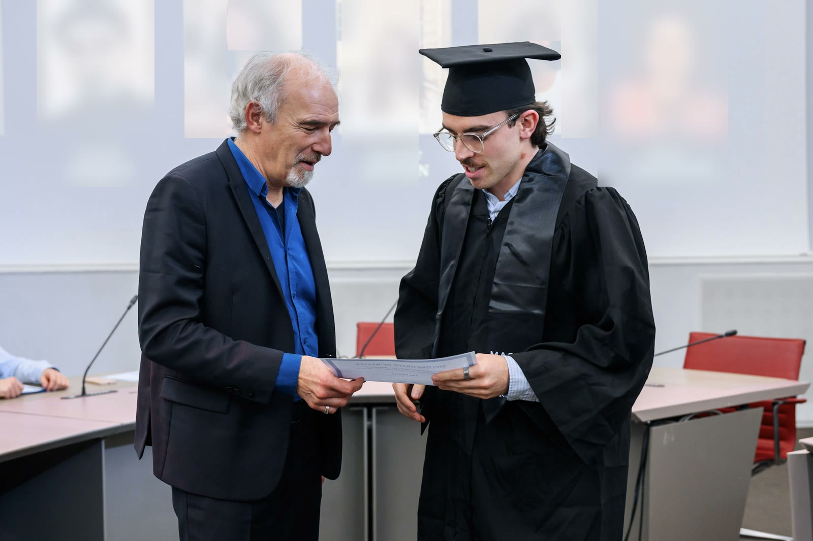Remise de diplôme dans une université américaine : un diplômé en toge reçoit son diplôme
